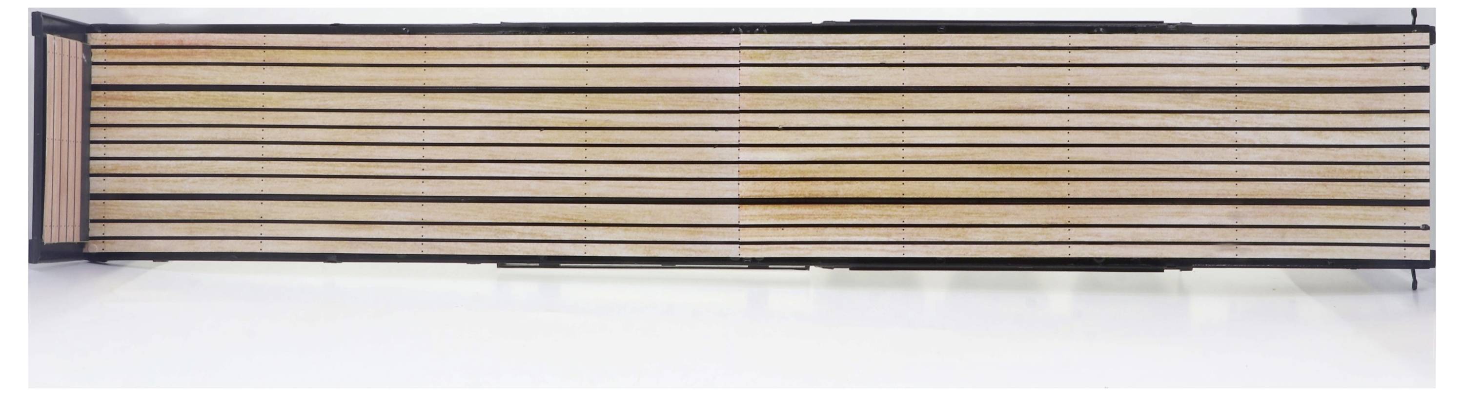 Drewniane deski na ścianie ułożone w nowoczesnym, symetrycznym wzorze, które tworzą minimalistyczne i wyrafinowane wrażenie.