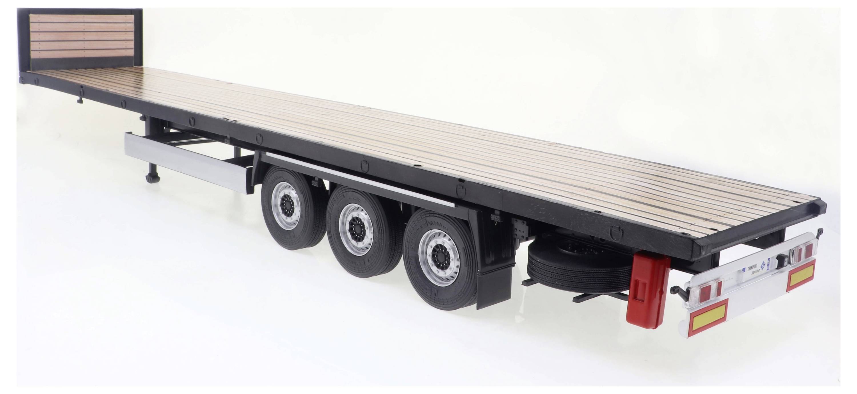 Długi przyczepa z trzema osiami, otwartą przestrzenią ładunkową i dekorowaną na drewno. Odpowiednia do transportu dużych towarów.