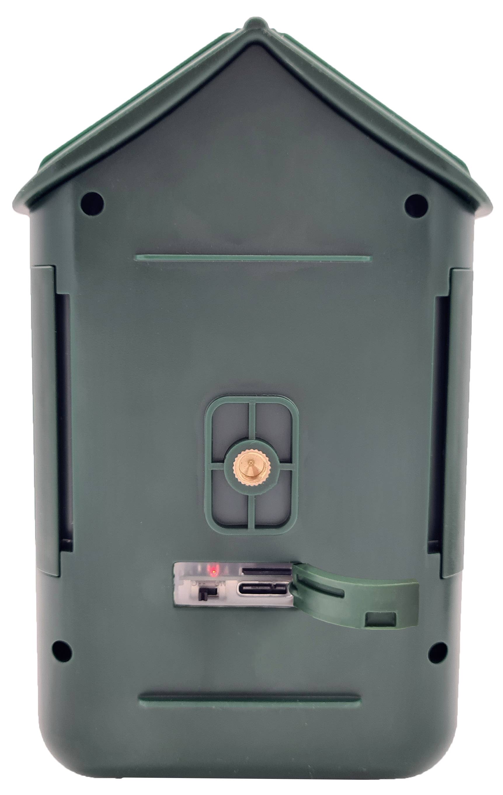 Zielona, prostokątna plastikowa pokrywa z małą klapką pośrodku, prawdopodobnie przeznaczona do przykrycia baterii lub złączy.