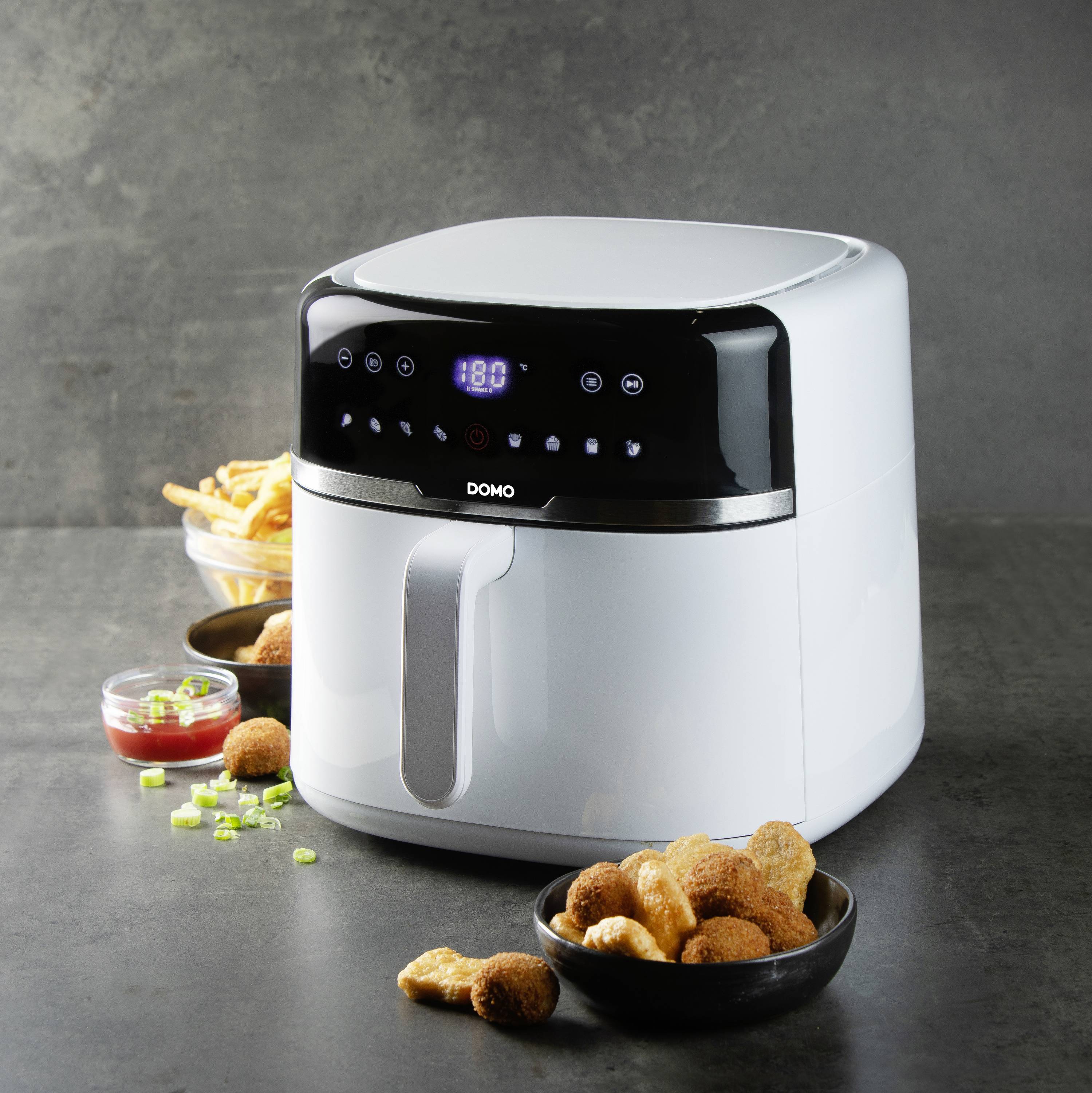 Frytownica na stole, otoczona smażonymi przekąskami i szczypiorkiem, wskazuje temperaturę 180 stopni.