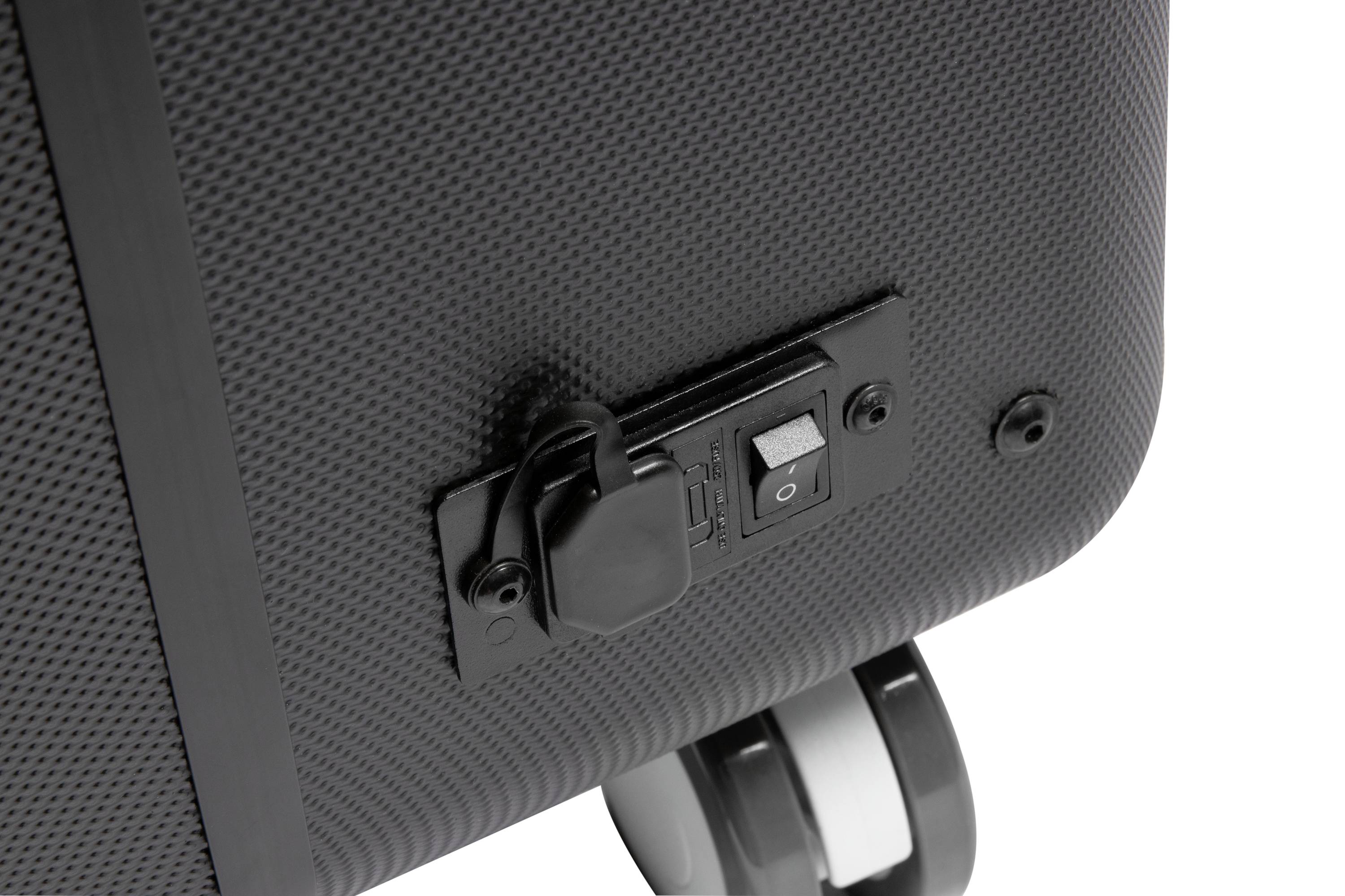 Zbliżenie czarnej walizki podróżnej z wbudowanym przełącznikiem i dwoma kółkami, leżącej na teksturowanej powierzchni.