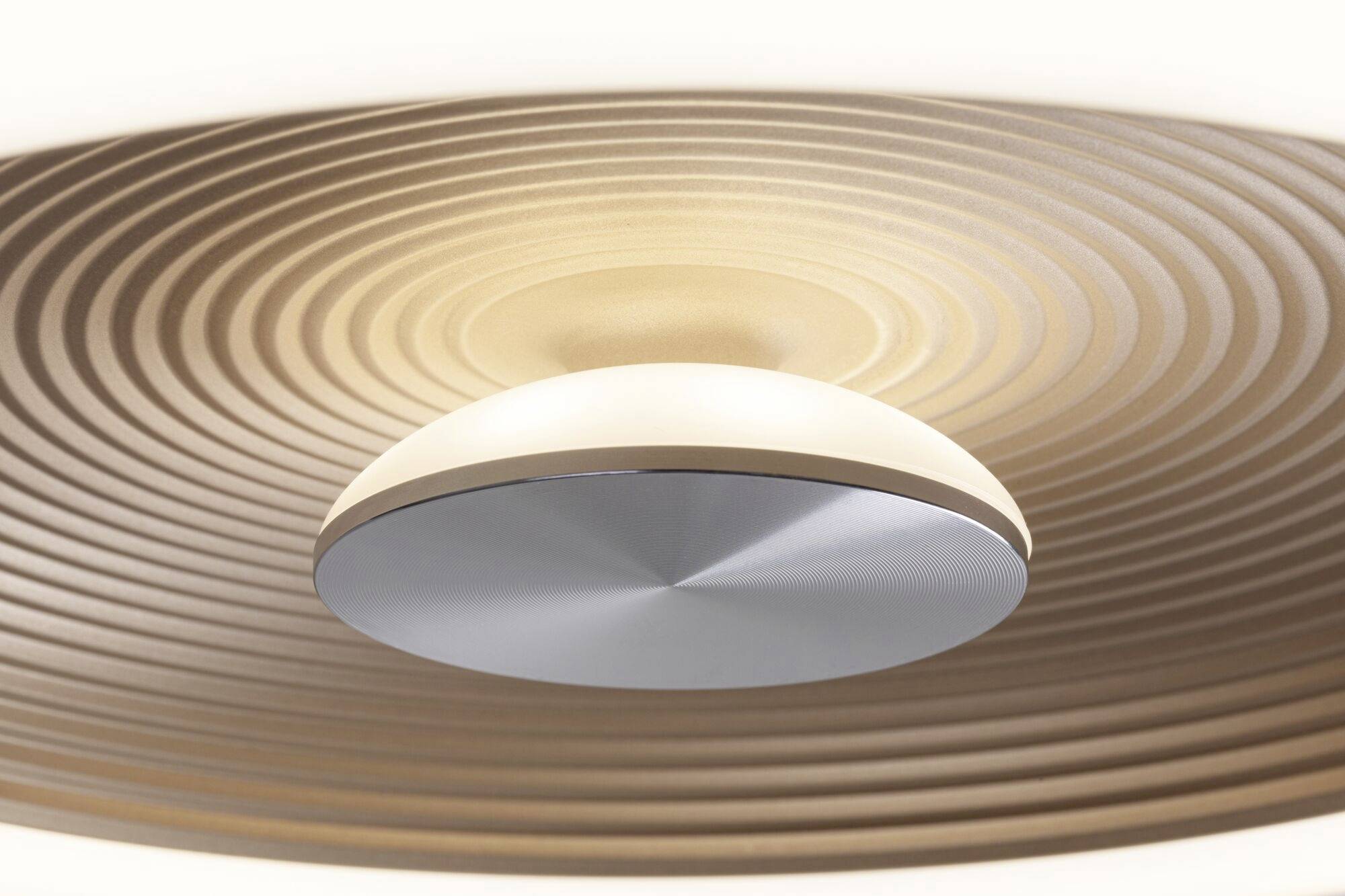 Nowoczesna lampa sufitowa o pierścieniowym, spiralnym kształcie, która emituje miękkie, rozproszone światło, zapewniając stylowe oświetlenie wnętrza.