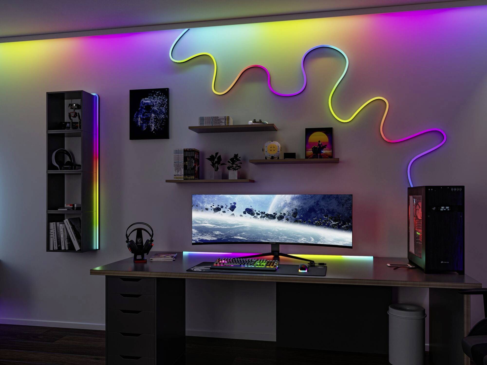 Nowoczesne biurko wyposażone w duży monitor i komputer. Kolorowe listwy LED ozdobione są na ścianie w tle.