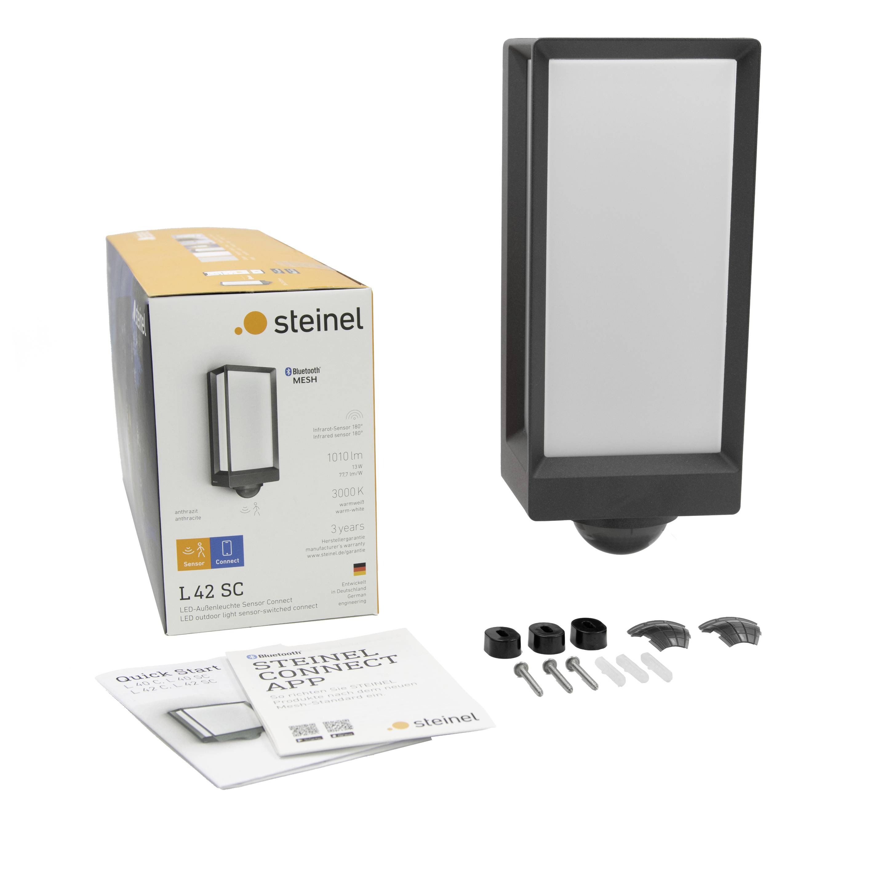 Lampa zewnętrzna o kwadratowym designie, opakowanie, instrukcje i materiały montażowe. Marka 'Steinel', model 'L 42 SC' z aplikacją Bluetooth connect.