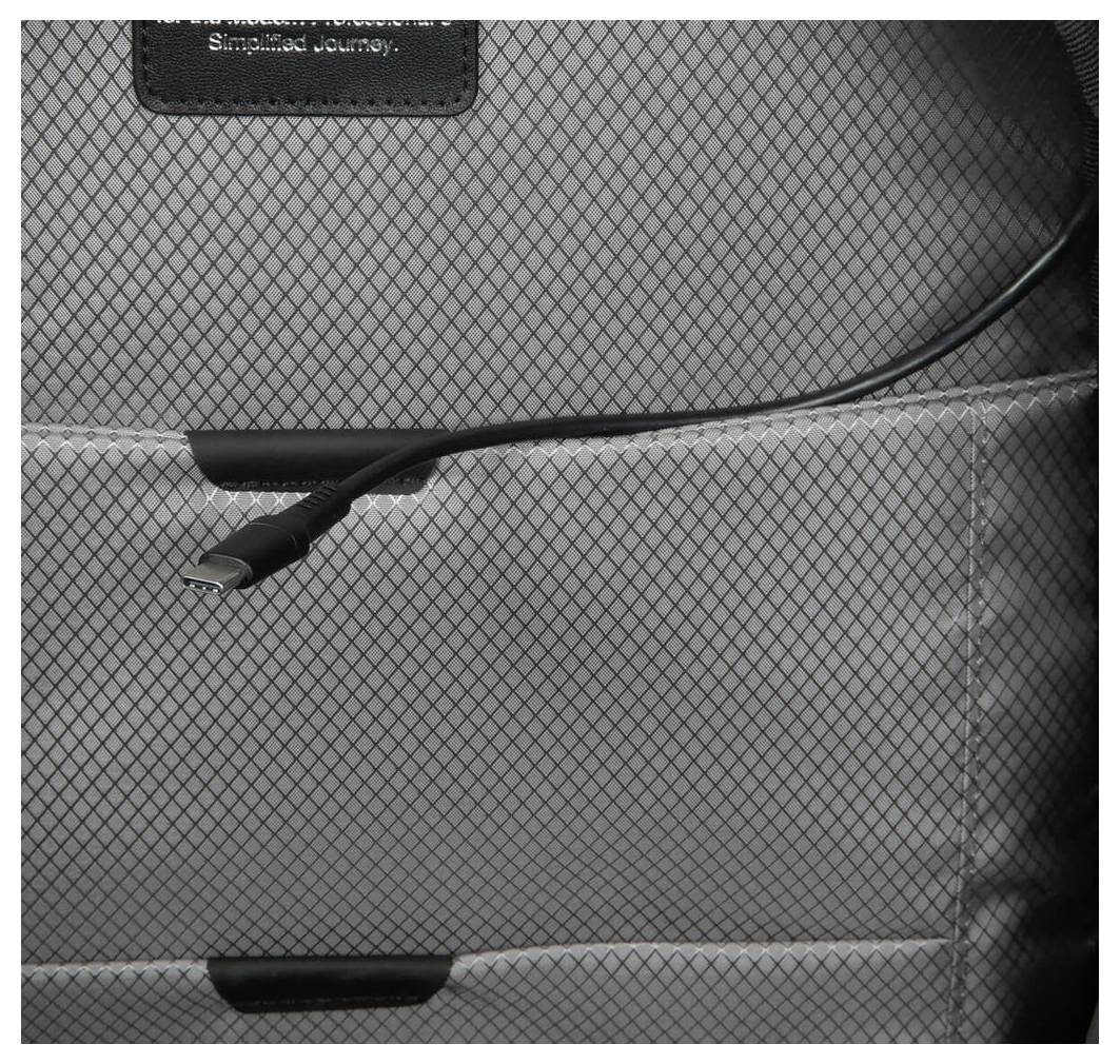 Kabel USB jest schowany w wewnętrznej kieszeni plecaka. Wewnętrzna tkanina ma szary, kratowany wzór.