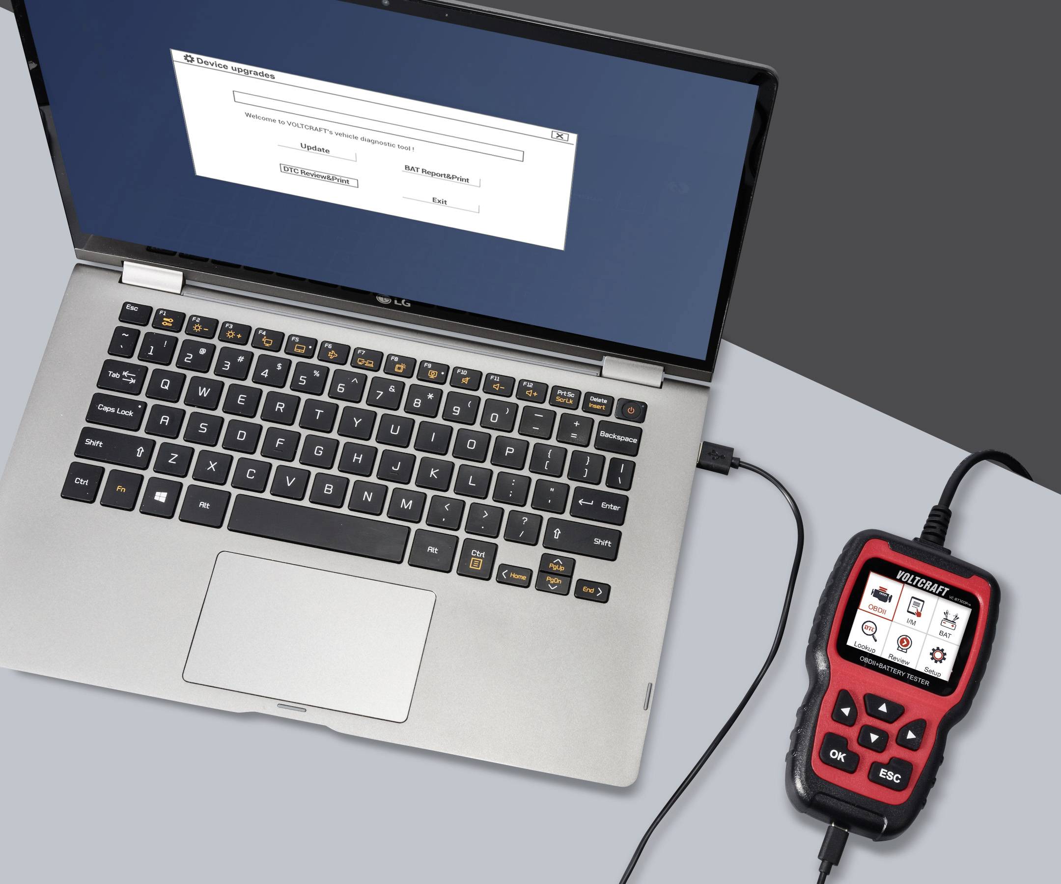 Laptop jest podłączony kablem do narzędzia diagnostycznego. Na ekranie laptopa wyświetlany jest interfejs oprogramowania.