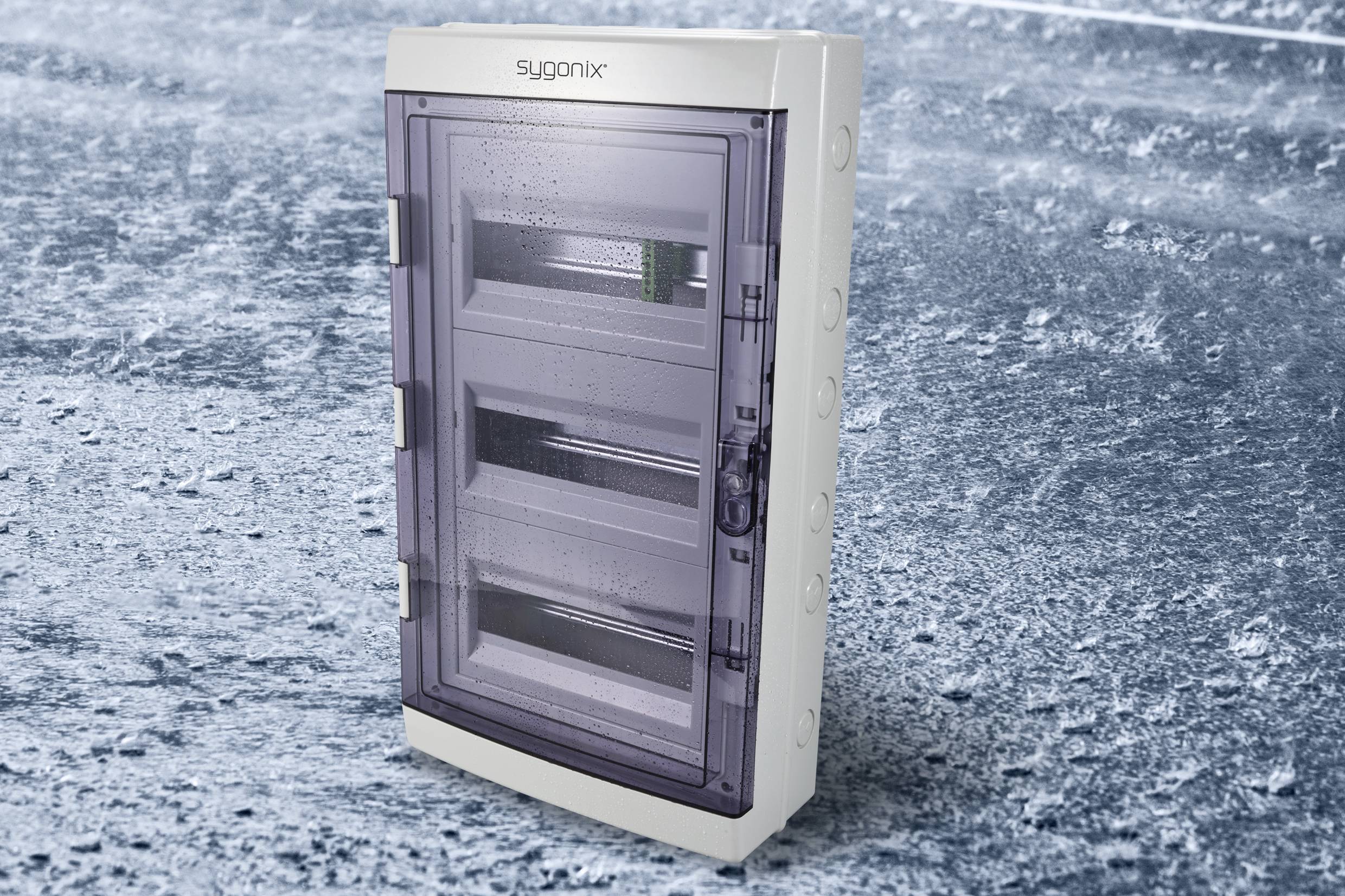 Szaro-niebieski pojemnik z trzema przegrodami, oznaczony napisem 'sygonix', stoi na lodowatym podłożu.