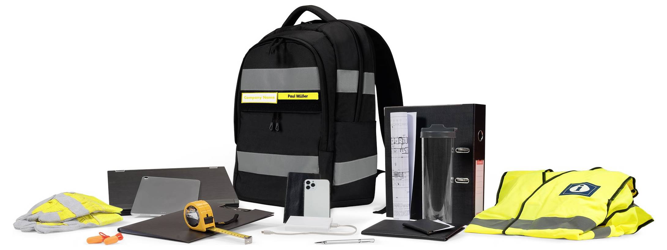 Plecak i kamizelka odblaskowa z pasami odblaskowymi, otoczone smartfonem, miarą, długopisami i notatnikiem. Zestaw środków ochrony pracy.
