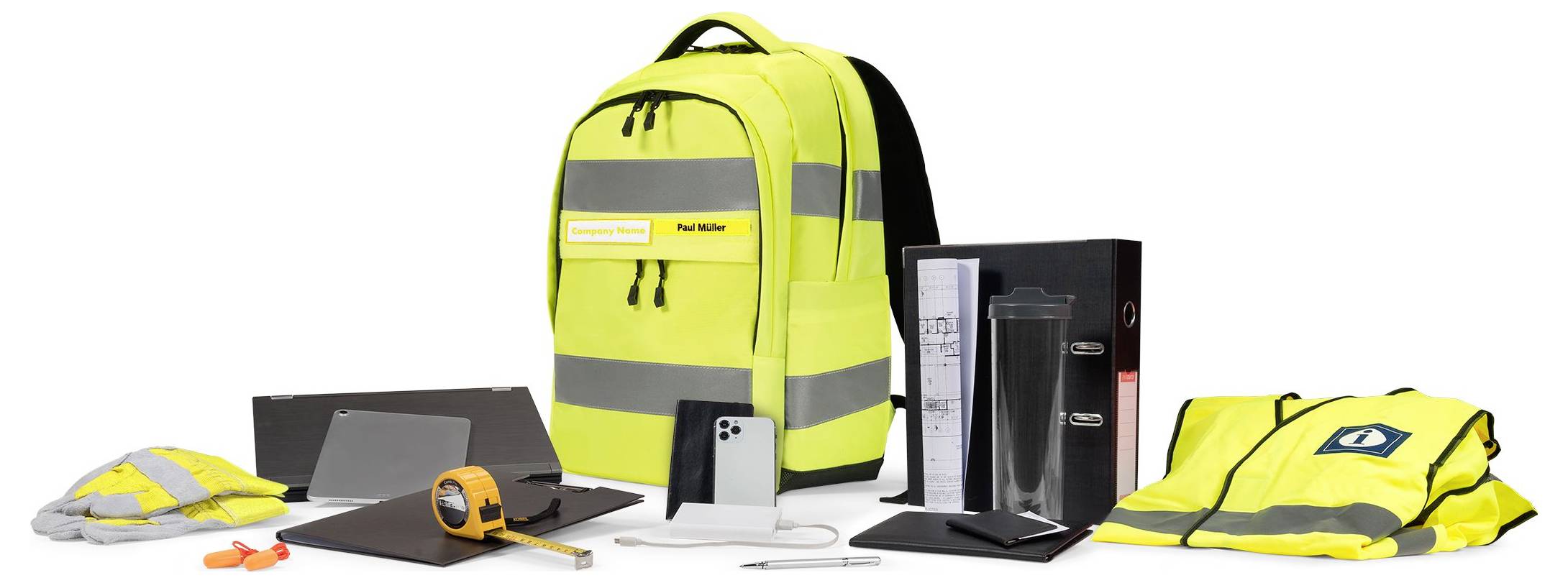 Żółty plecak z odblaskowymi paskami otoczony jest kamizelką odblaskową, hełmem, telefonem komórkowym, miarą, termosem i segregatorem.