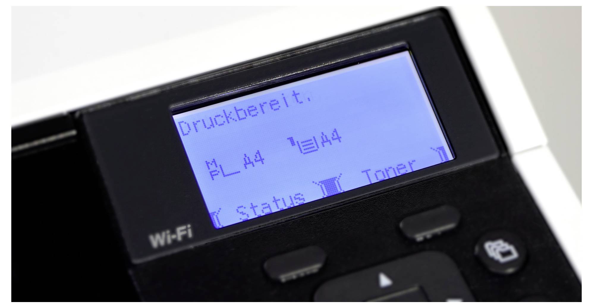 Wyświetlacz drukarki pokazuje 'Gotowa do druku' z formatem papieru A4 i statusem tonera. Symbol Wi-Fi widoczny w lewym dolnym rogu.