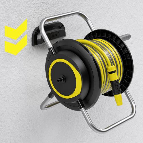 Żółta szpula z wężem w czarnej ramie jest zamontowana na szarej ścianie. Obok widoczne są dwa żółte strzałki.