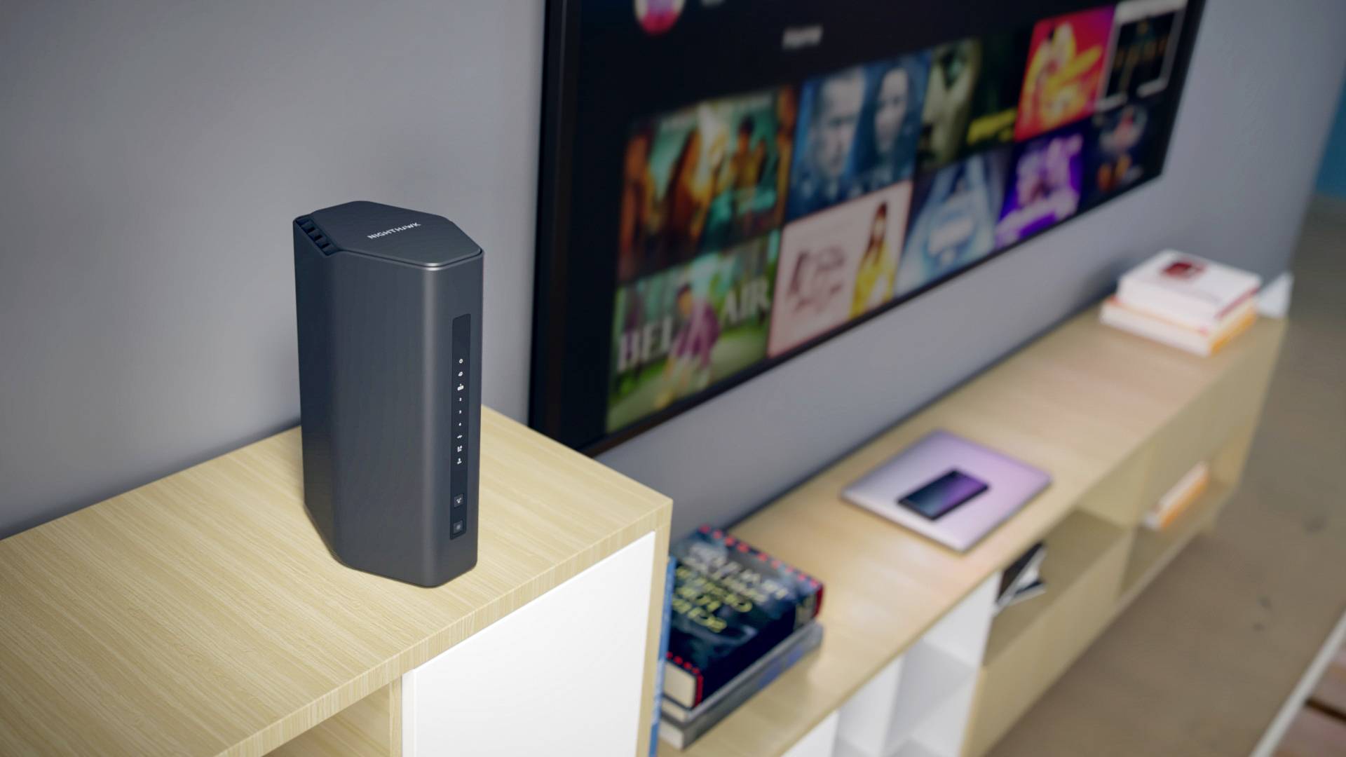 Czarny głośnik na stole obok pilota; w tle nieostry ekran płaskiego telewizora.