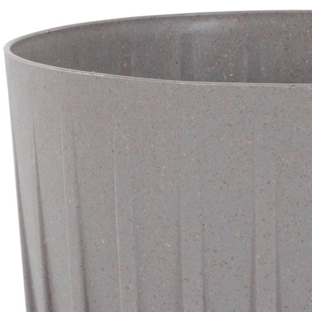 Szary, cylindryczny kosz na śmieci, pusty.