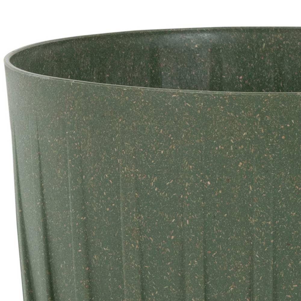 Duży, zielony doniczka wykonana z materiału o nakrappanej powierzchni; posiada lekko żłobkowaną strukturę.
