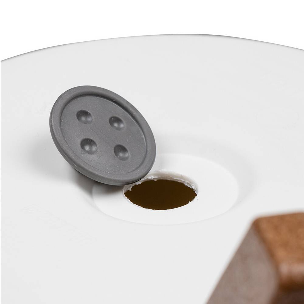 Rolka z szarym guzkiem do ręcznego zakładania dziurek na białym tle, prawdopodobnie z zestawu do szycia lub pudełka z materiałami craft.