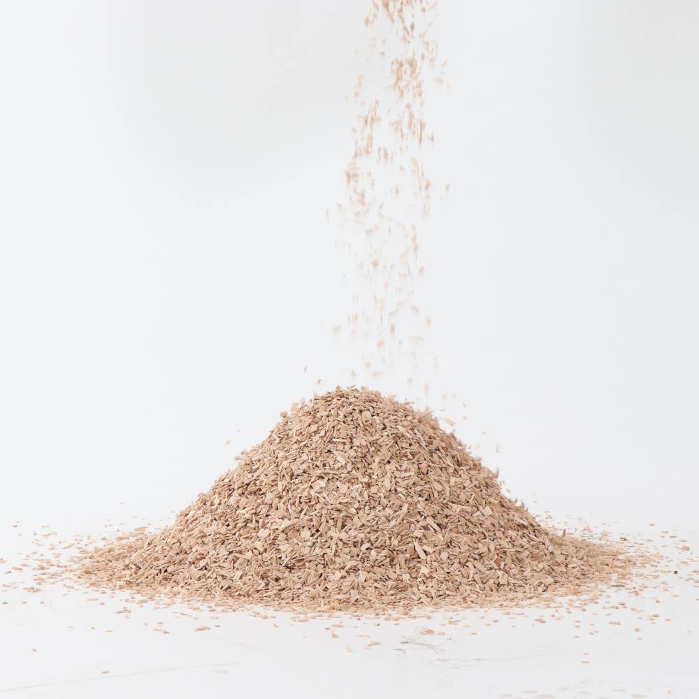 Sterta trocin na jasnym tle, z trocinami opadającymi z góry.