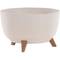 Okrągła, kremowa doniczka wsparta na trzech krótkich brązowych nóżkach.