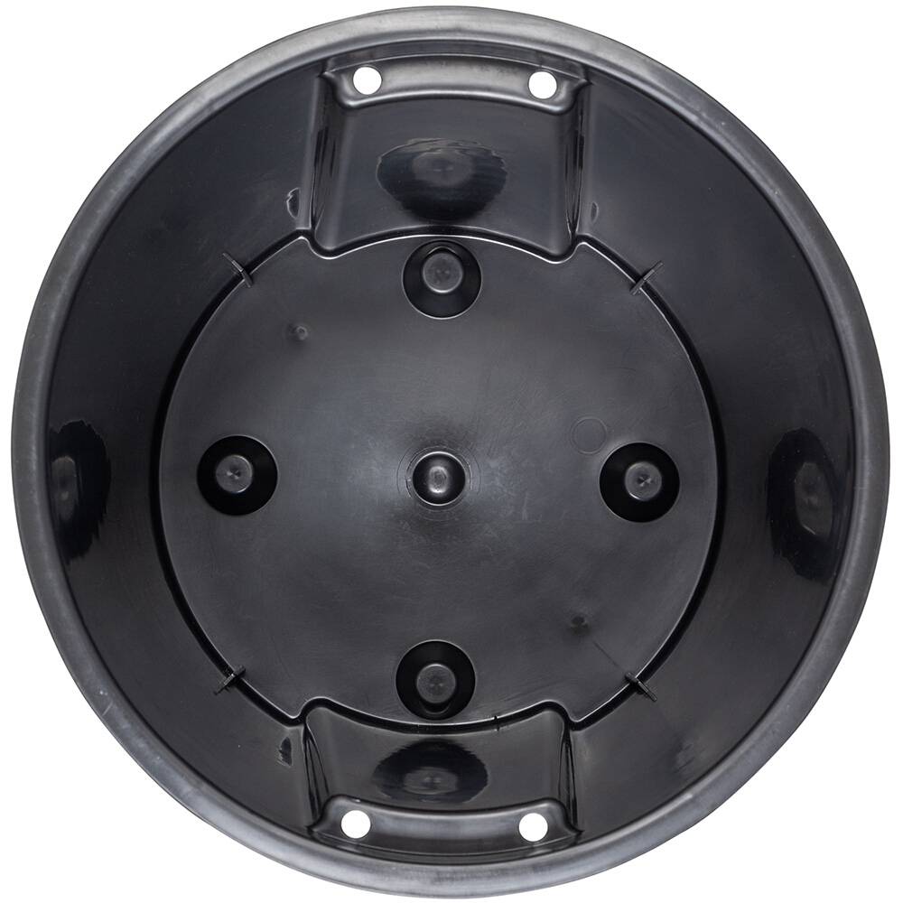 Okrągły, czarny plastikowy doniczka, widziany z góry, z kilkoma otworami odpływowymi na dnie.