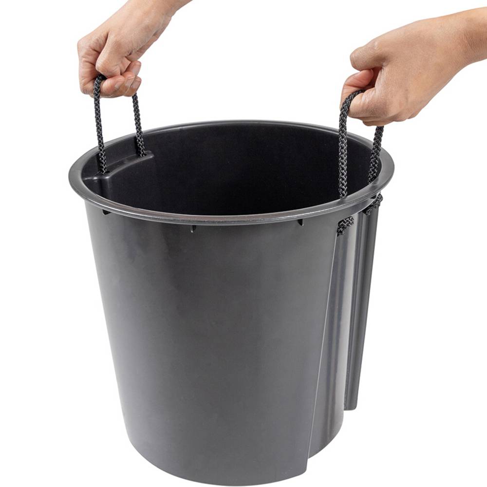 Dwie ręce trzymają czarny plastikowy wiadro z uchwytami po bokach. Wiadro jest puste.