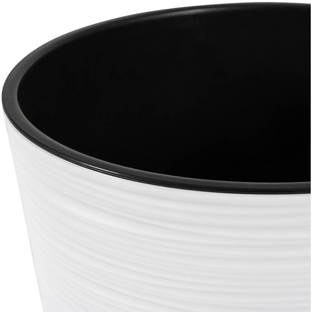 Biały, żłobiony doniczka z czarną obwódką.