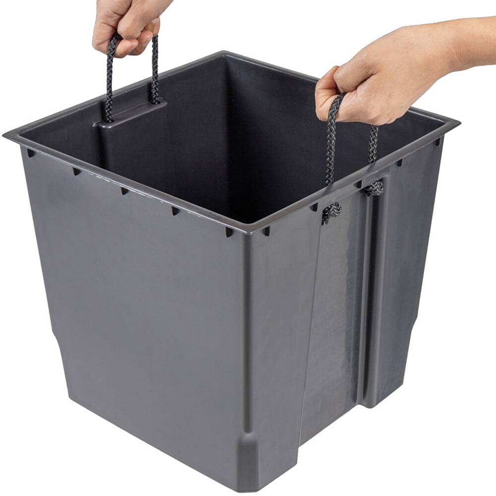 Osoba trzyma pusty, szary prostokątny pojemnik z tworzywa sztucznego za boczne sznury.