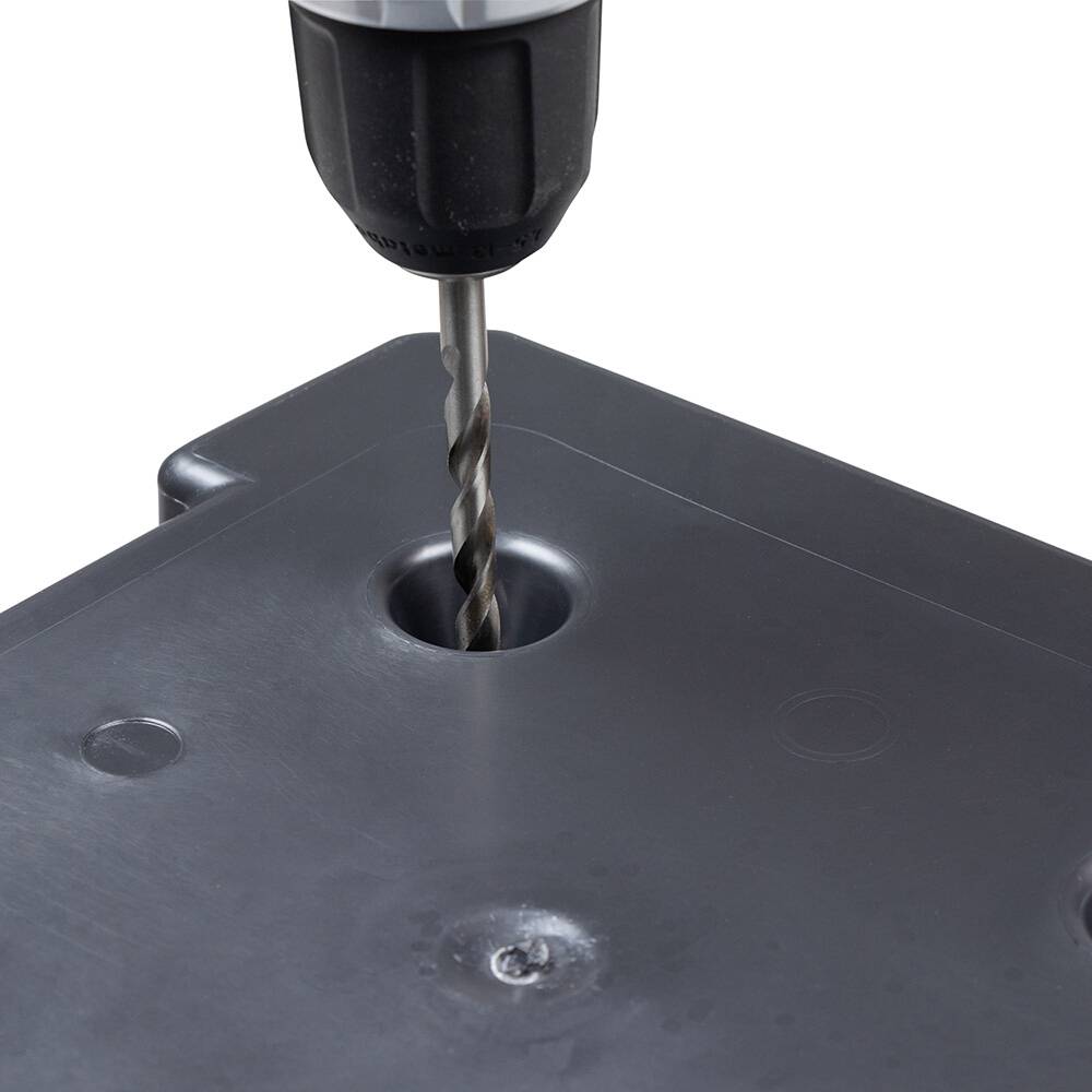 Wiertarka z wiertłem wykonuje otwór w szarej metalowej powierzchni.