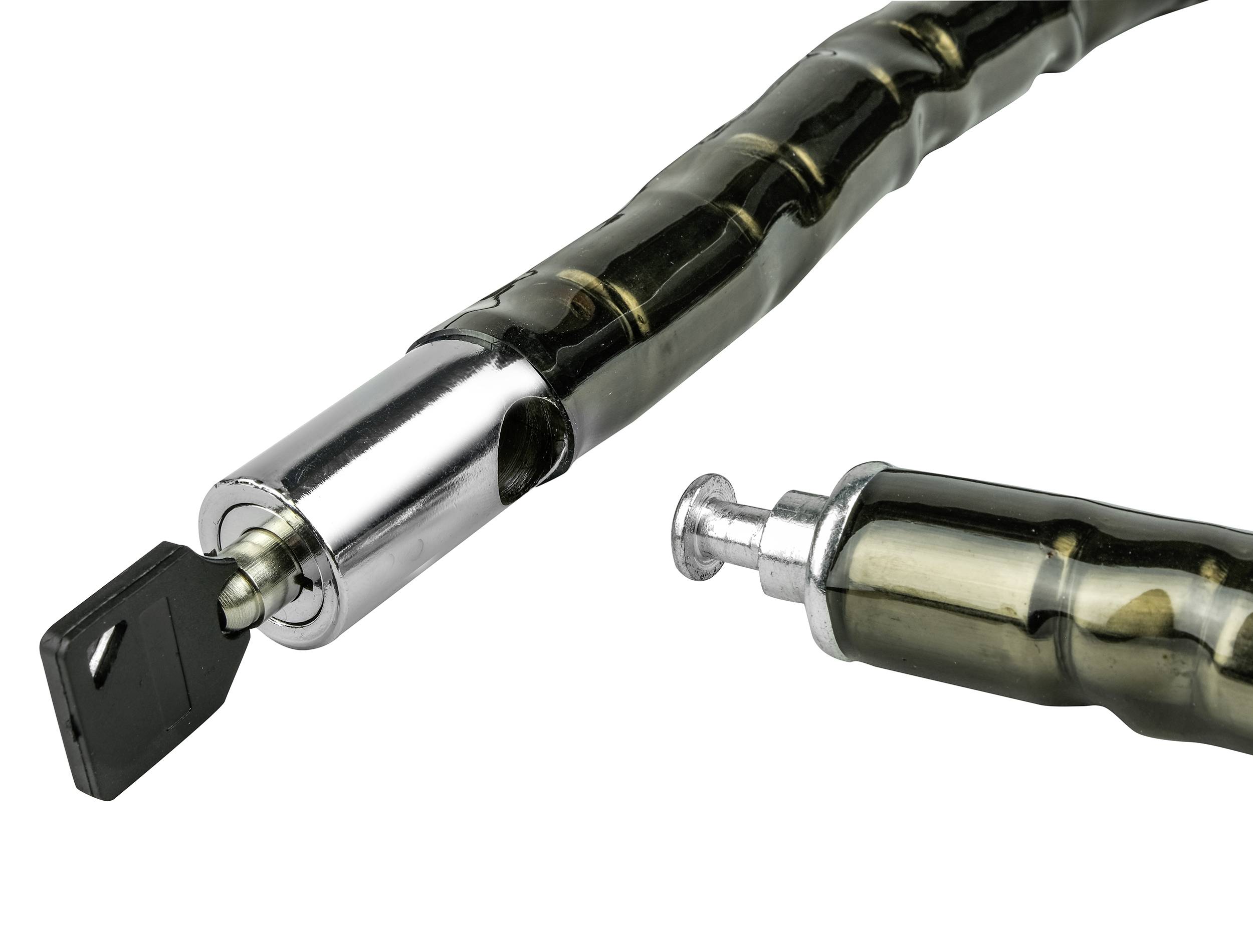 Metalowy zamek rowerowy z włożonym kluczykiem i rozłożonym niezabezpieczonym przewodem, sfotografowany na białym tle.