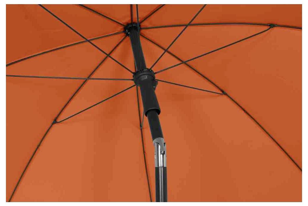 Otwarty, pomarańczowy parasol widziany od dołu, z wyraźnie widocznymi żebrami i konstrukcją ramową.