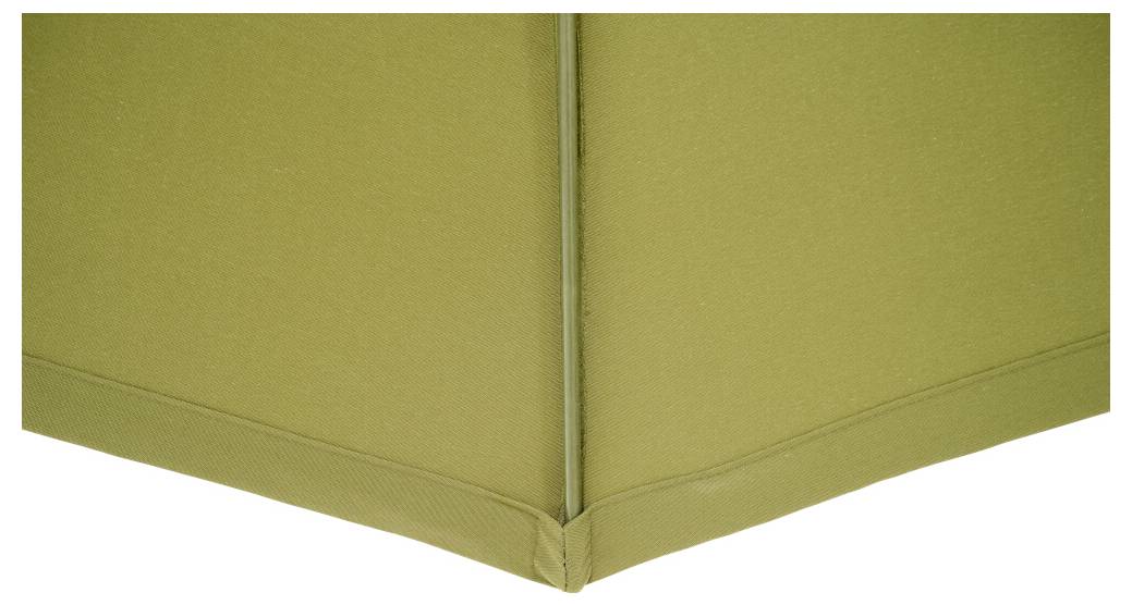 Zielona, wyłożona tapicerką narożna strefa pokoju o czystych liniach i zróżnicowanej fakturze.