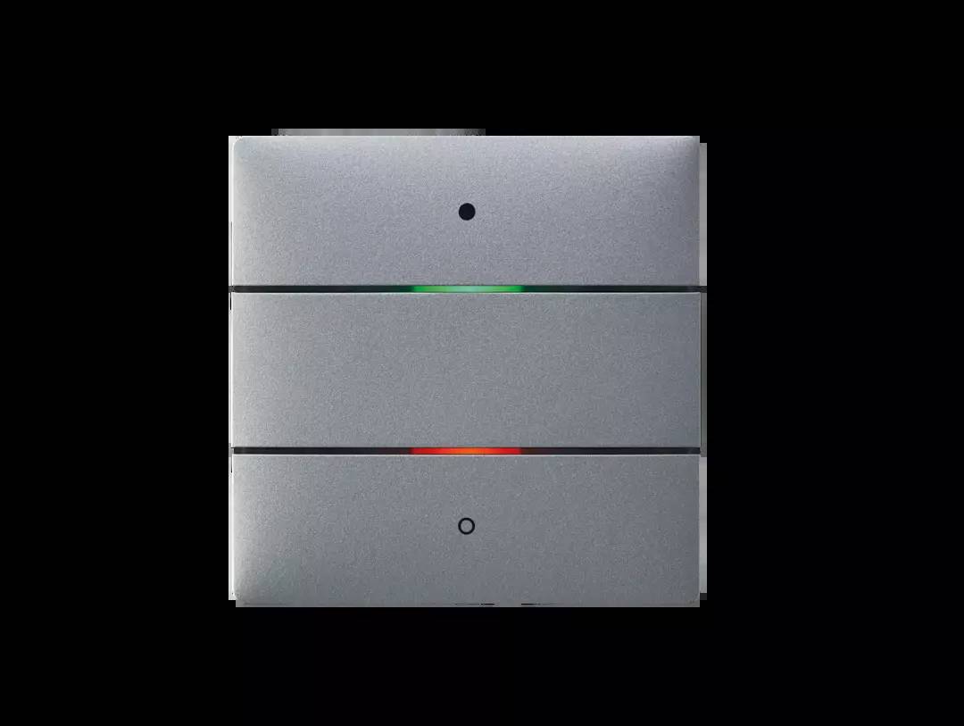 Szary przełącznik z dwoma przyciskami. Górny przełącznik świeci się na zielono, dolny na czerwono. Prawdopodobnie do sygnalizacji różnych stanów.