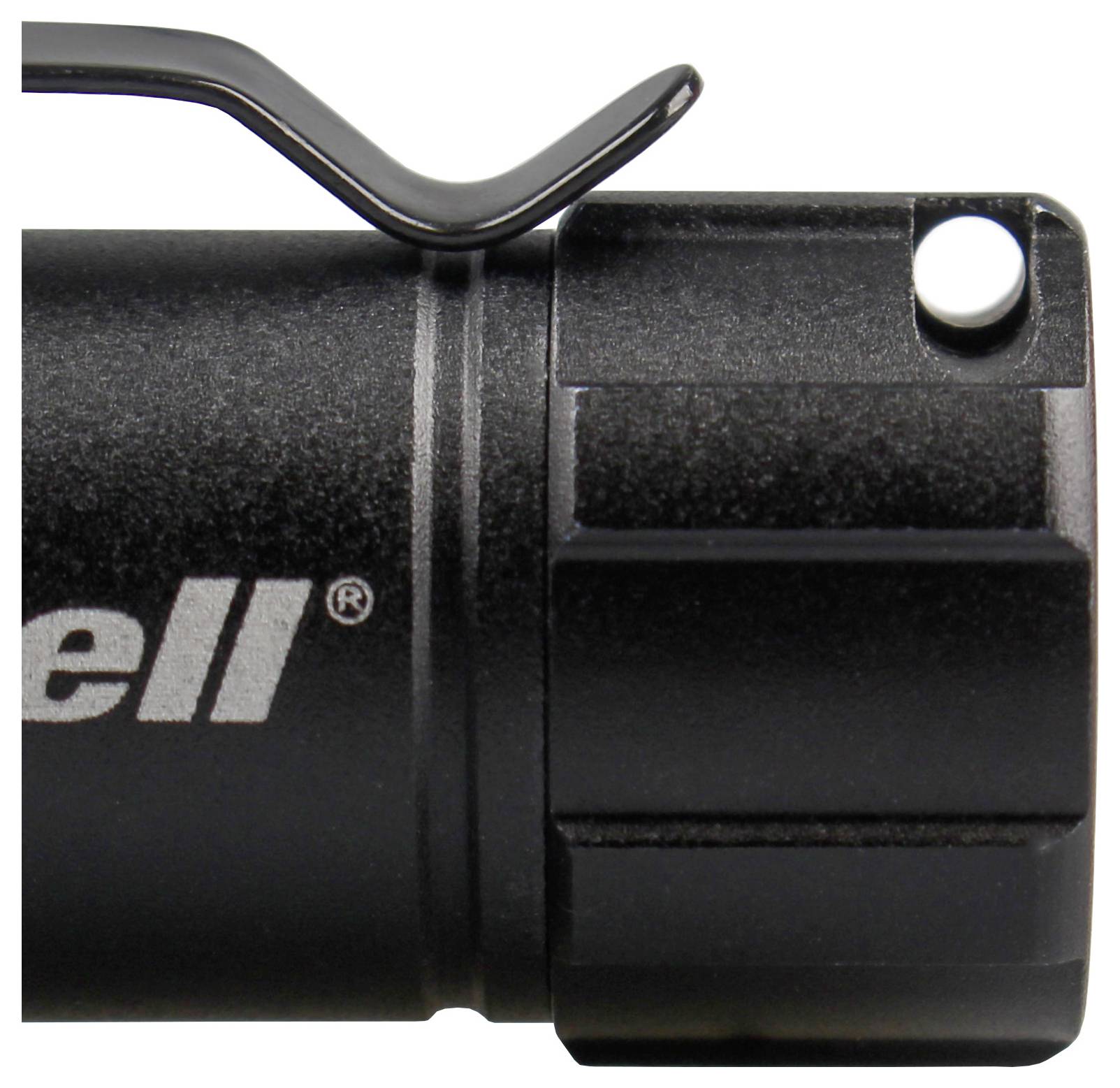 Zbliżenie głowicy czarnej latarki z klipsem i przyciskiem. Widoczna jest tylko część nazwy marki.