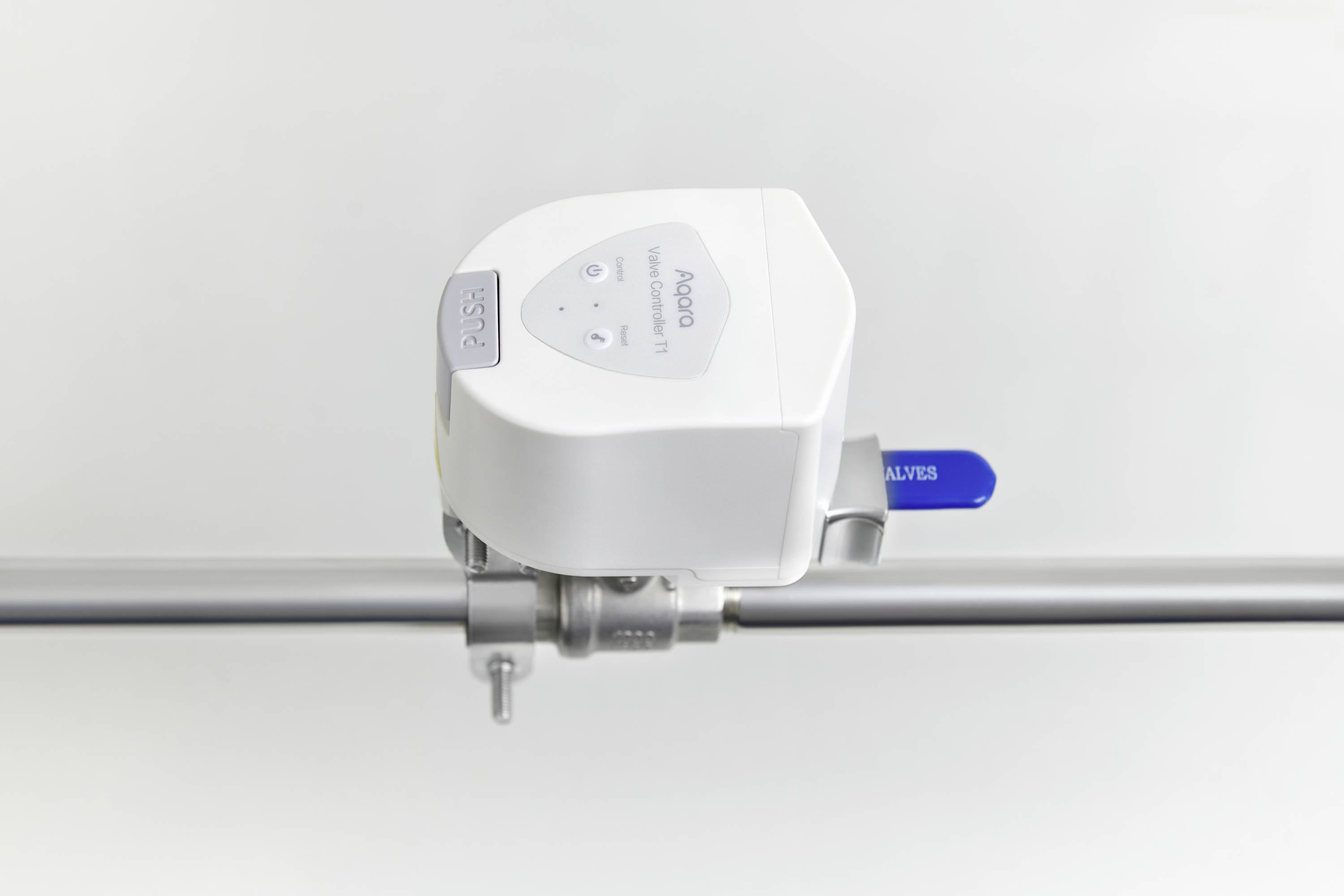 Automatyczny zawór na rurze, z niebieską dźwignią i białą obudową, oznaczony napisem 'BOSS'.