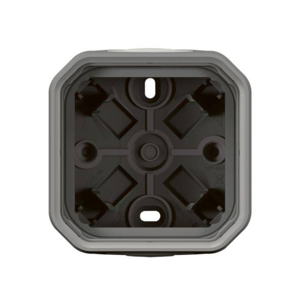 Szara lub czarno-szara, kwadratowa, pusta puszka montażowa z wieloma otworami na śruby w narożnikach, przeznaczona do instalacji elektrycznych.