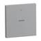Szary, kwadratowy przełącznik z plusem na górze i minusem na dole. Służy do sterowania urządzeniami elektronicznymi.