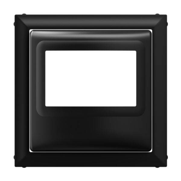 Czarny, kwadratowy plastikowy ramka z prostokątnym, pustym otworem pośrodku. Odpowiednia do montażu włączników lub gniazd elektrycznych.