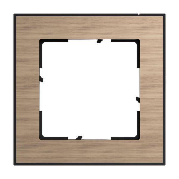 Drewniana rama do włącznika światła z kwadratową przestrzenią wewnętrzną i czarną wewnętrzną krawędzią, odpowiednia do dekoracji lub montażu.