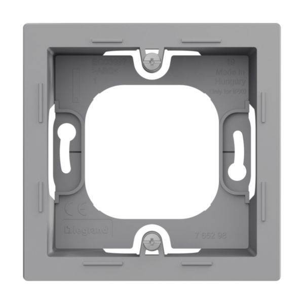 Szary kwadratowy ramka z tworzywa sztucznego, z czterema otworami na śruby w narożnikach oraz białymi zaciskami po obu stronach. Widoczna nazwa marki 'Legrand'.