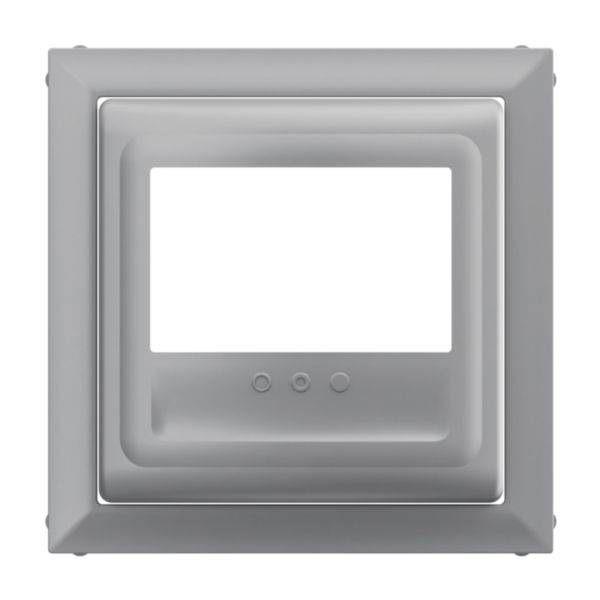 Szary, kwadratowy ramka z prostokątnym wcięciem pośrodku oraz trzema małymi, okrągłymi zagłębieniami na dole.