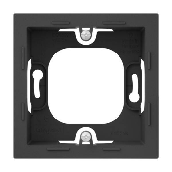 Kwadratowa ciemna plastikowa rama, odpowiednia do montażu podtynkowego gniazd elektrycznych. Zawiera cztery otwory na wkręty do mocowania.