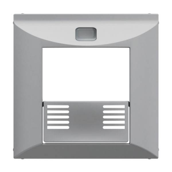 Szara ramka włącznika światła z klapką zakrywającą gniazdo elektryczne pośrodku.