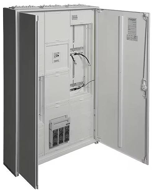 Otwarty rozdzielnik elektryczny z widocznymi przewodami i komponentami wewnątrz. Na wewnętrznej stronie drzwiczek widoczna jest tabliczka znamionowa producenta.