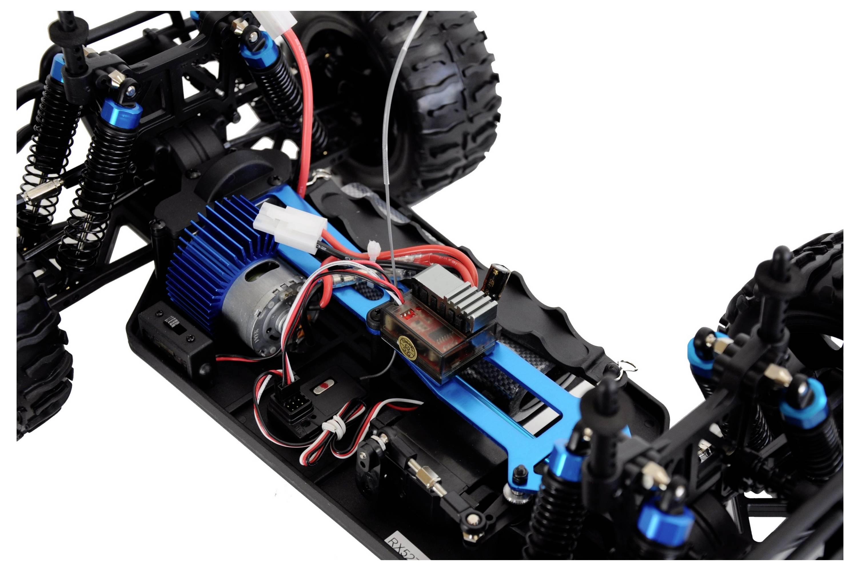 Zbliżenie zdalnie sterowanego samochodu, ukazujące silnik, instalację elektryczną i zawieszenie; nacisk położony na technikę i budowę.