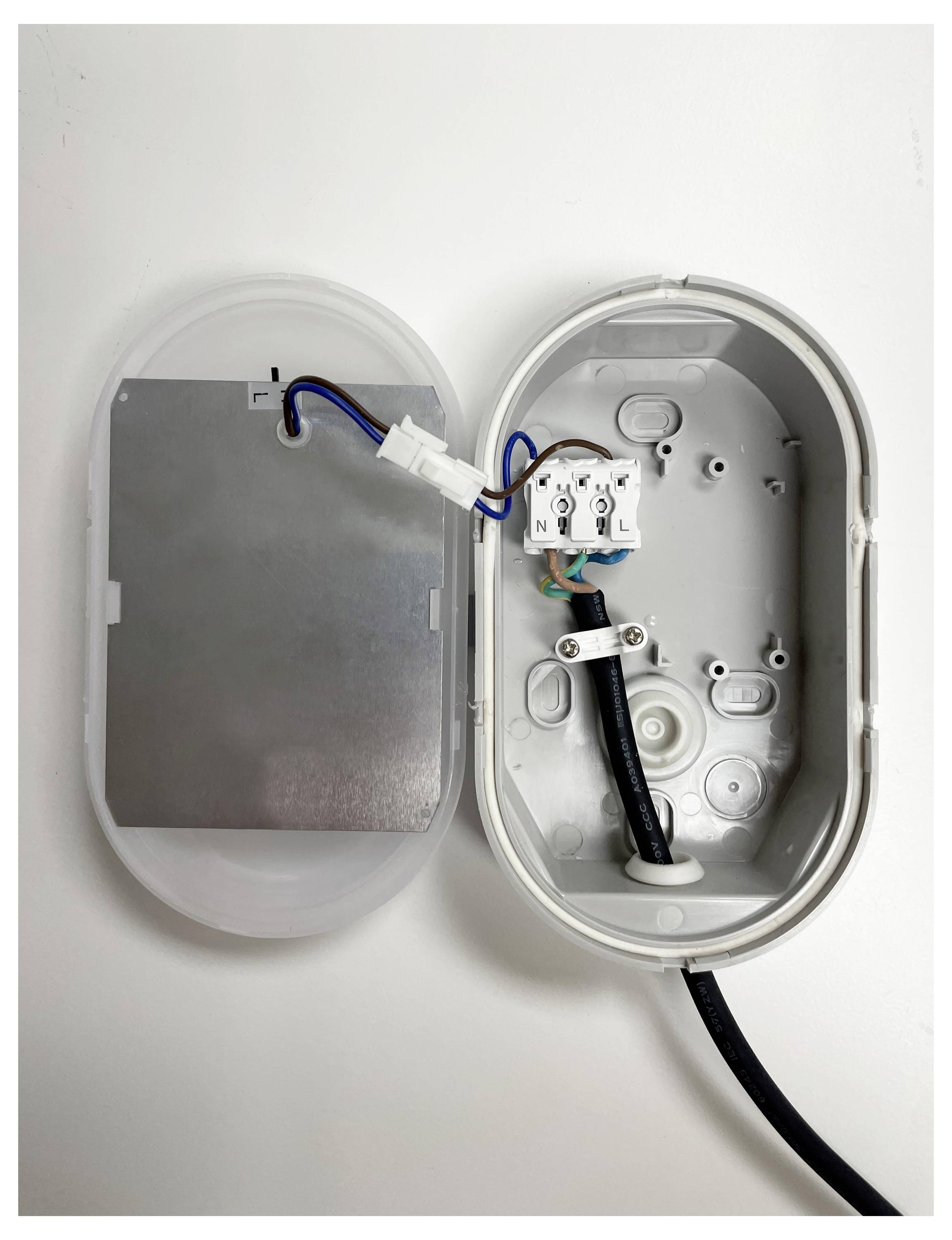 Otwarty elektryczny panel sterujący z widocznymi przewodami i złączami. Brak jakichkolwiek osłon ochronnych.