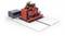 Czerwony robot na białej platformie, podłączony do szarego pudełka. Robot posiada wiele kabli i elementów mechanicznych.