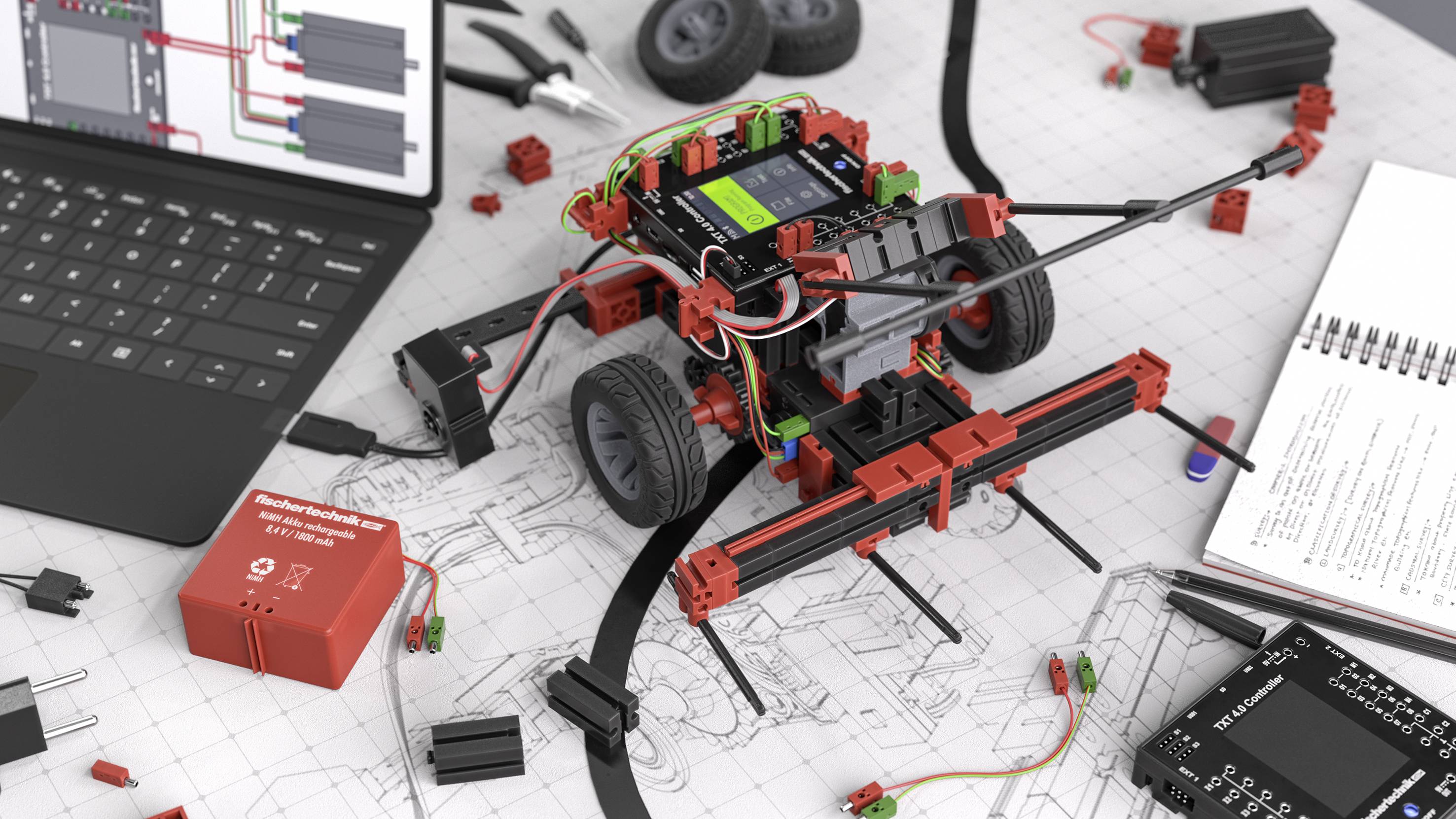 Zestaw do budowy robota na biurku z laptopem, notatnikiem i kamerą; prezentujący szczegóły techniczne i komponenty elektroniczne.