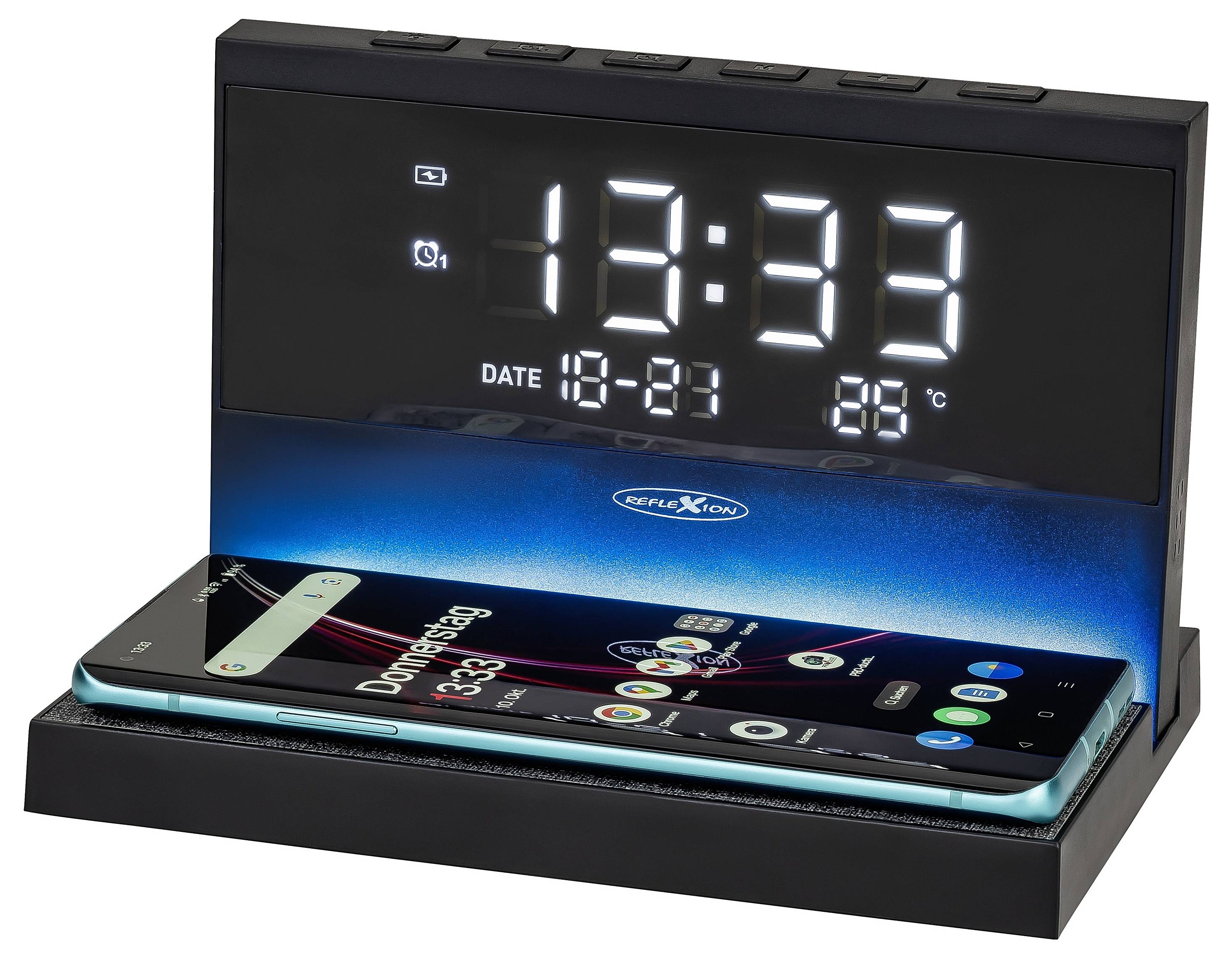 Czarna cyfrowa stacja alarmowa wyświetlająca 12:33, datę 18-21 i 88°C podczas ładowania smartfona na jej podstawie.