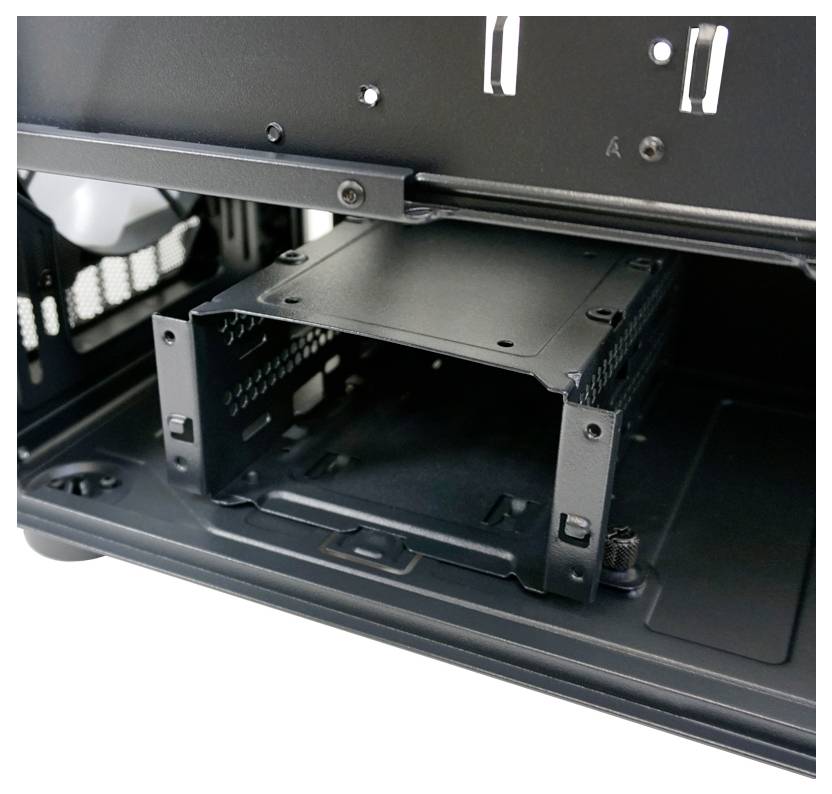 Widok wnętrza obudowy przedstawia pusty kosz na dyski twarde w obudowie komputera, gotowy do zainstalowania dysków.