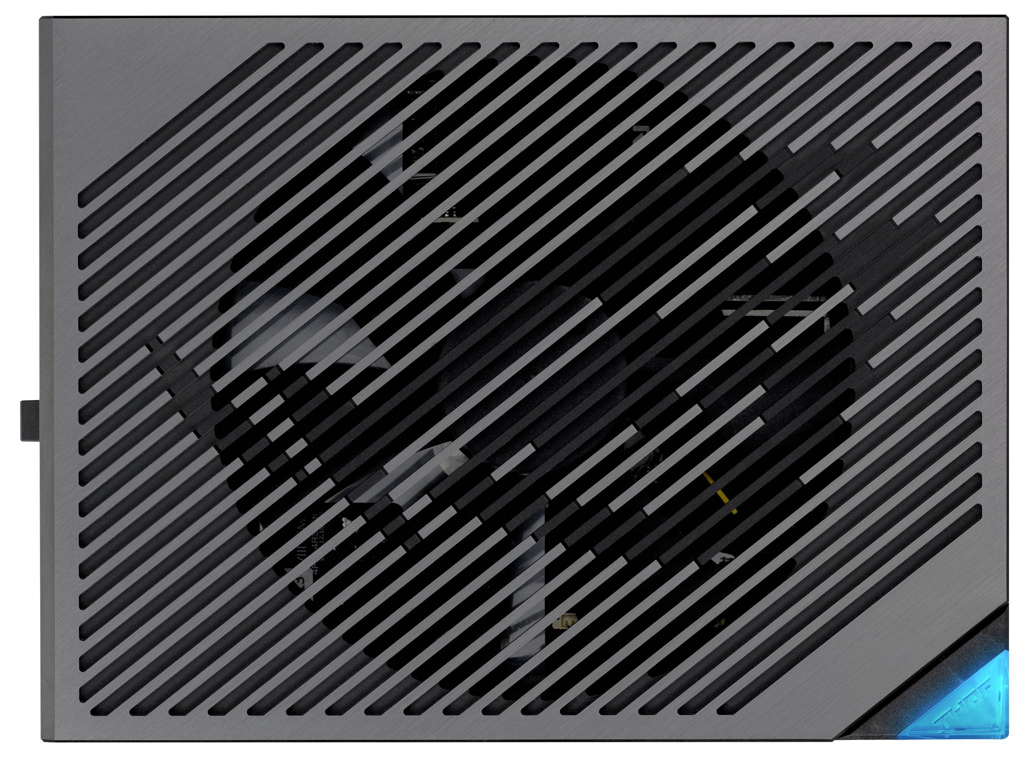 Czarny zasilacz komputerowy z kratką wentylatora, zakrywającą jego łopatki; kluczowy element odpowiedzialny za zasilanie komputera w energię elektryczną.