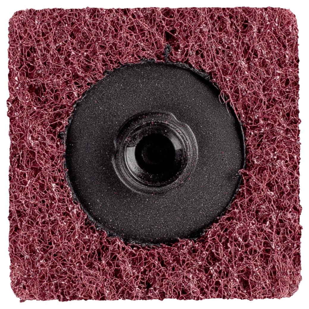 Czerwona gąbka do szorowania z czarną, okrągłą plastikową głowicą pośrodku, używana do czyszczenia lub obróbki powierzchni.