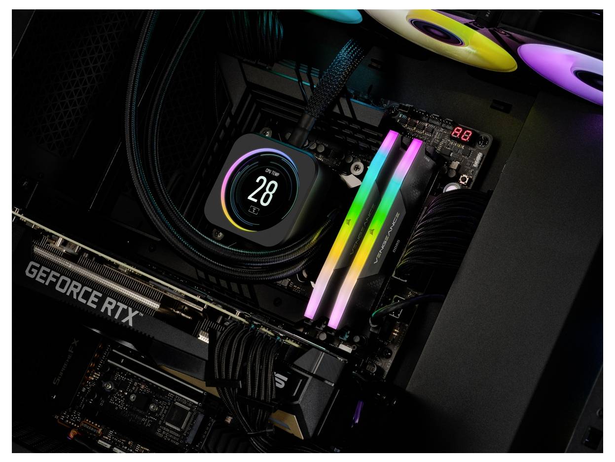 Widok wnętrza komputera z świecącym radiatorem i kartą graficzną oznaczoną jako 'GEFORCE RTX'. Kolorowe diody LED świecą się.